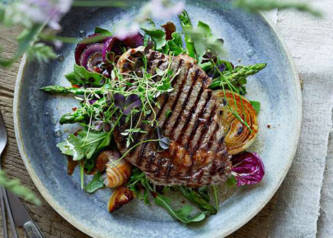 Grillet entrecote med tilbehøret asparges, salat og løk